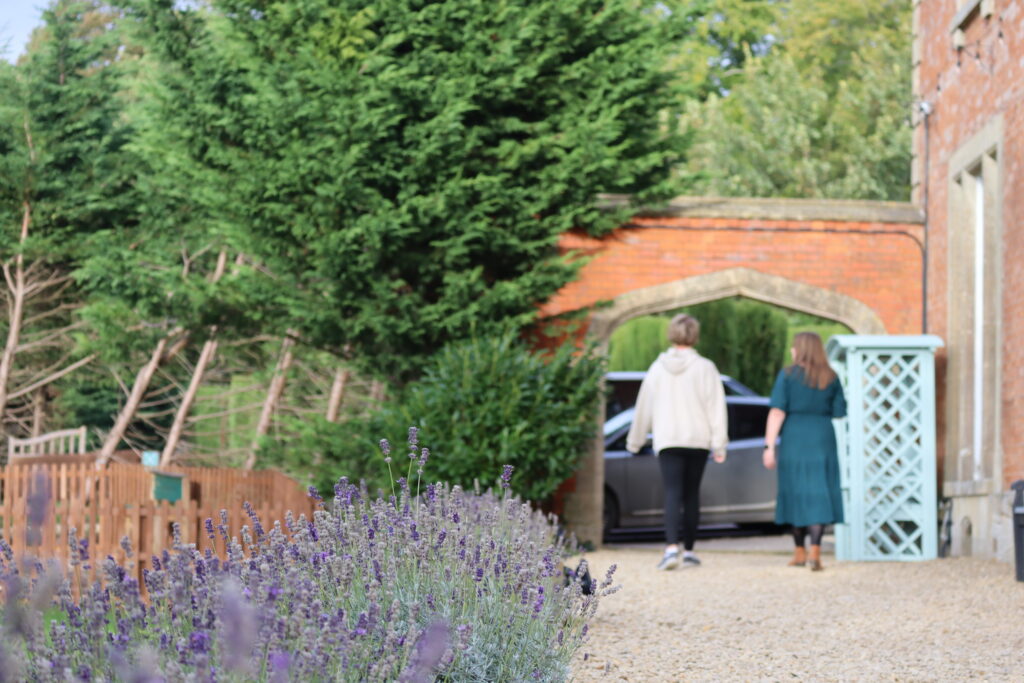 Visitors walking through the lavender garden towards the school entrance